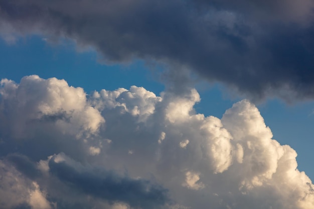 Fluffy cumulus clouds on blue sky background Cloudscape white and grey color