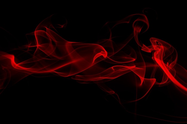 Fluffy puffs of red smoke and fog on black background