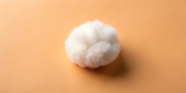 Photo fluffy white cotton ball on peach fuzz color background