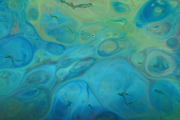 Fluid art. Dark green stains of paint on the water. Abstract paint background