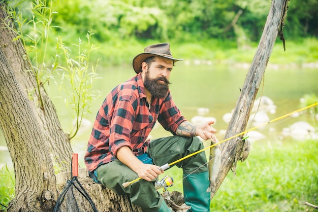 Fly fishing in the pristine wilderness of Canada Happy fisherman fishing in river holding fishing ro