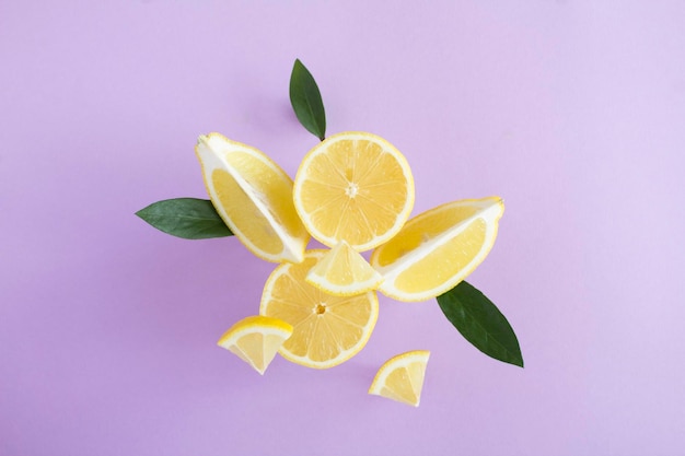 Flying in air fresh ripe whole and lemon with leaves on the purple background Closeup