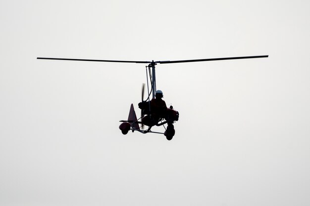 Photo flying autogyro silhouette on white background.