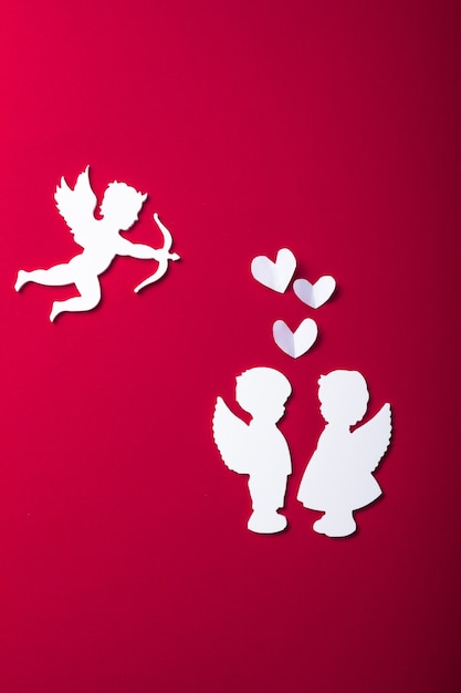 Flying cupid silhouette, two white angel,  happy Valentine's Day banners, paper art style. Amour on red paper