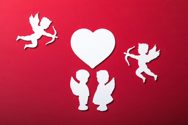 Flying cupid silhouette, two white angel,  happy Valentine's Day banners, paper art style. Amour on red paper