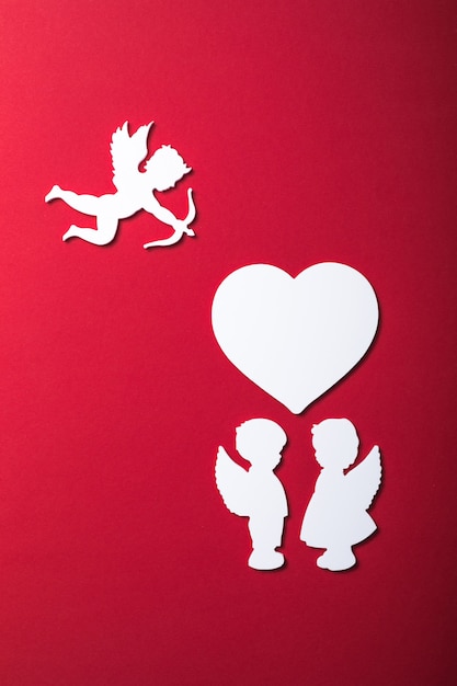 Flying cupid silhouette, two white angel,  happy Valentine's Day banners, paper art style. Amour on red paper