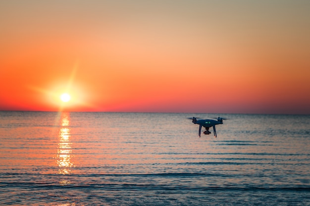 Flying drone on a of sea sunset