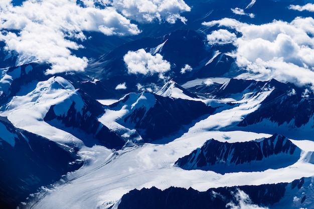 Flying over the frozen mountain range, to Leh in Ladakh. Aerial view from the plane window.