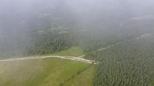 Flying over the green slopes of the Carpathian mountains in the clouds