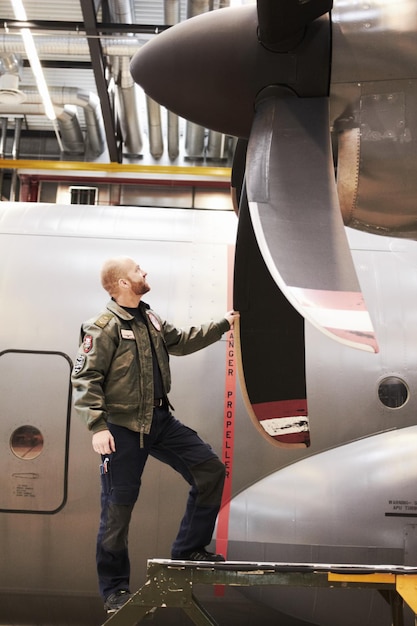 Flying machine Full length shot of a pilot inspecting the propellor of his plane