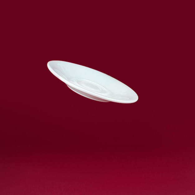 Flying White Porcelain plate on red background Morning and addiction concept