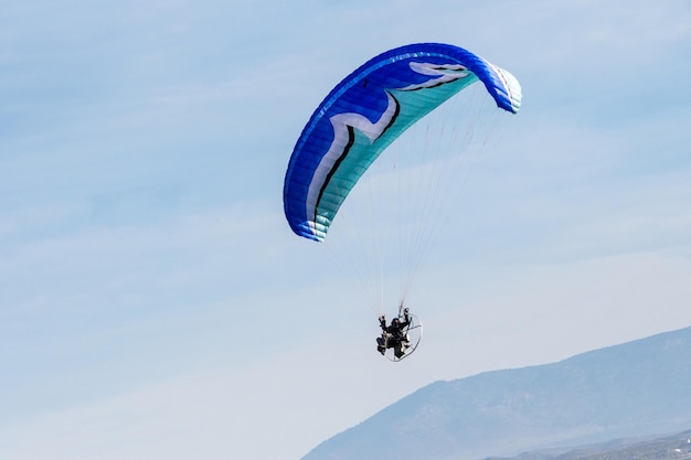 Flying with paramotor in the air on blue sky background