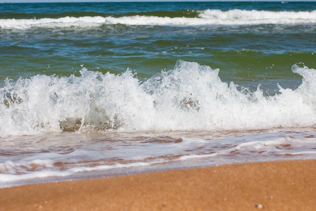 Photo foam waves on a sandy beach seascape