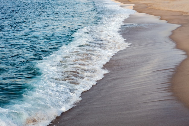 Foamed waves breaking in the beach