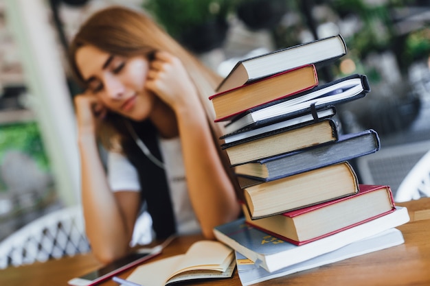 Focus on the book with busy girl in the cafe.