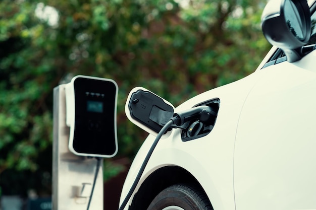 Focus closeup EV car and charger with blur background for progressive concept