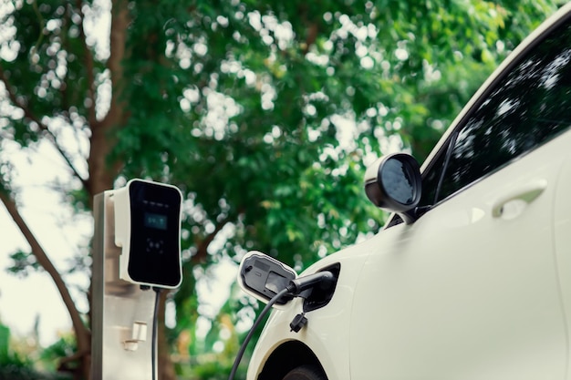 Focus closeup EV car and charger with blur background for progressive concept