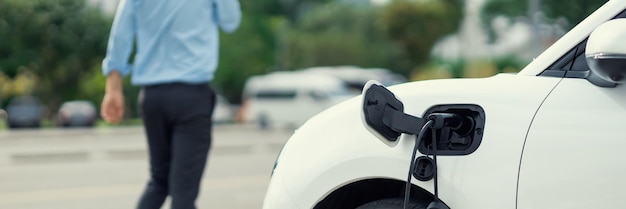 Focus closeup EV car recharge battery at public charging station