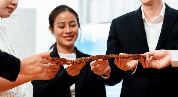 Focus closeup hands holding gears join together by blur office worker in harmony