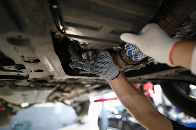 Focus on hardworking male hands examining modern high-tech automobile