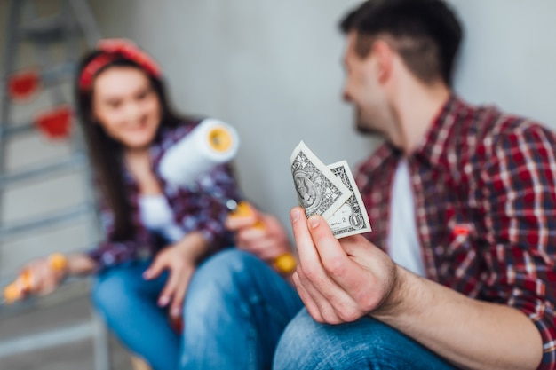 Focus at man doing repair with his girl, they holding money