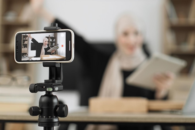 Focus on phone screen muslim woman recording video on phone camera while unpacking box