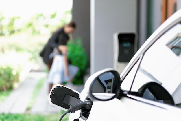 Focus progressive EV car at home with blur woman in background