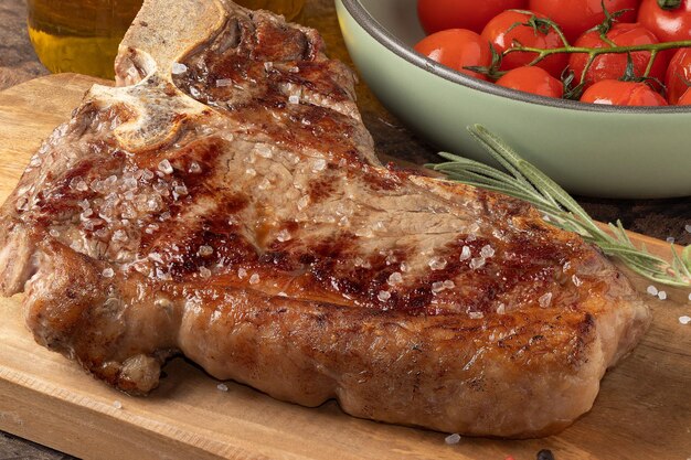 Focus on T bone grilled steak on cutting board