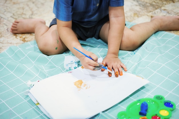 Focus on their hands on paper. Children use brushes to draw their hands on paper to build their imagination and enhance their cognitive skills.