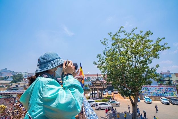 Focus young girl take photo at Linh Phuoc Pagoda or Ve Chai Pagoda is a buddhist dragon temple in Dalat city in Vietnam