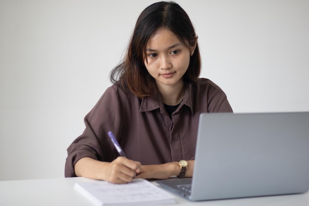 Focused asian woman using laptop at office during the day