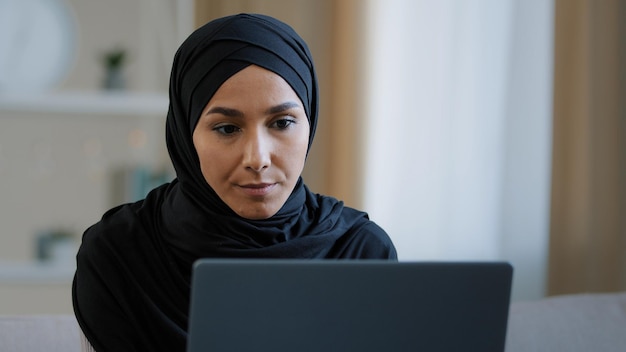 Focused ethnic female muslim arabian young woman girl islamic student businesswoman freelancer sits