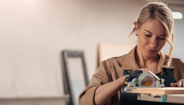 Focused Female Carpenter Using Circular Saw Skilled Craftswoman in Woodworking Workshop