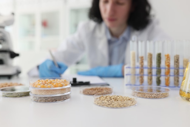 Focused male scientist writes notes while examining crops for scientific purposes man sits at