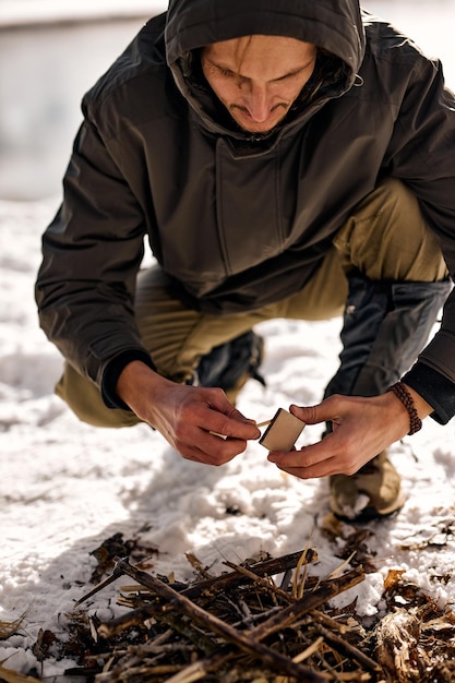 Focused male starts a fire in forest in nature forest made by male person