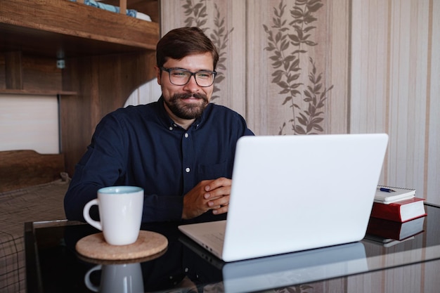 Focused man sitting at desk watching webinar video course