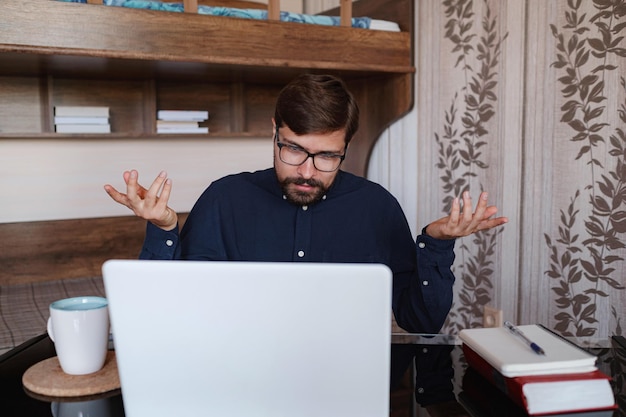 Focused man sitting at desk watching webinar video course