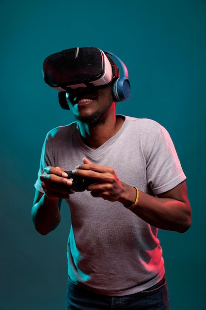 Focused man using controller and vr glasses to play futuristic game online. Gamer playing virtual reality simulation on interactive headset with joystick, advertising 3d modern technology.