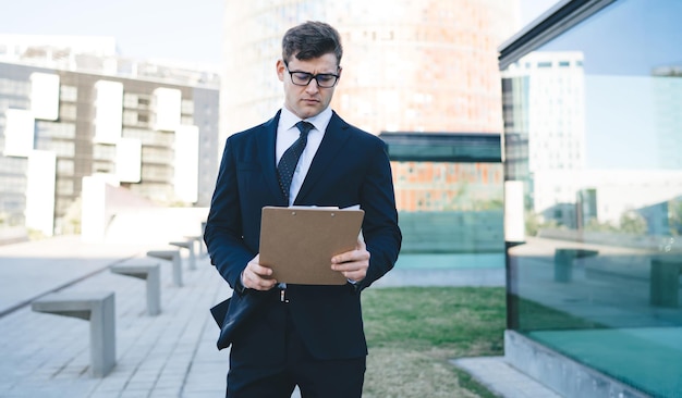 Focused young man reading clipboard