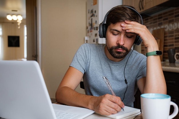 Focused young man wear headphones study online