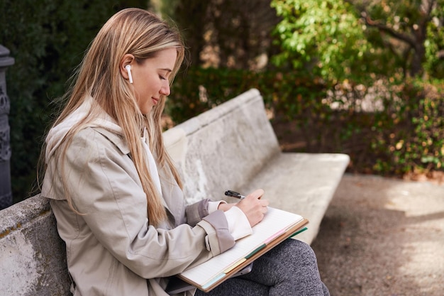 Focussed Caucasian woman multitasking with music and studying