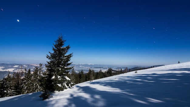 Fog moving over the mountain in winter with a starshaped sky