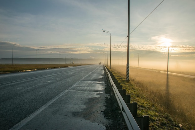 Fog on the road along the field at dawn fog in the autumn field along the highway Ulyanovsk