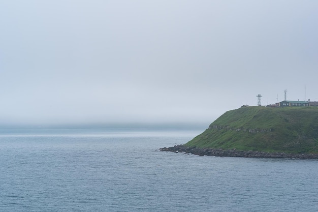 Foggy cape with a telecommunication point in a gloomy sea