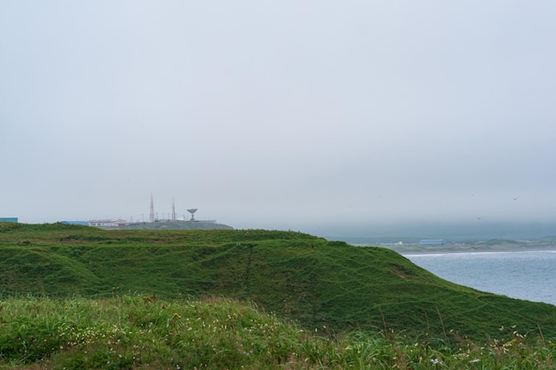 Foggy cape with a telecommunication point in a gloomy sea