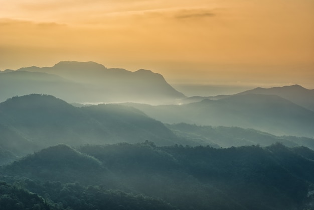 Foggy in the mountains with dramatic sky at sunrise