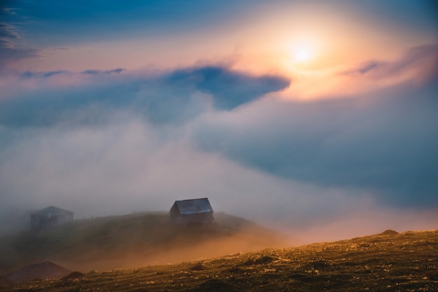 Foggy Sunset And Old Village In Mountains