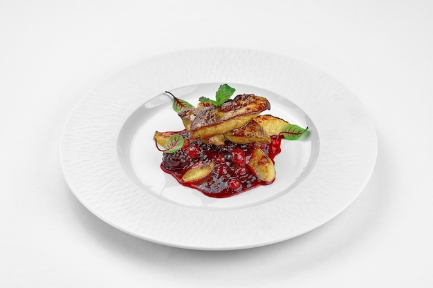 Foie gras with berry sauce on a white plate on a white plate Closeup Selective focus