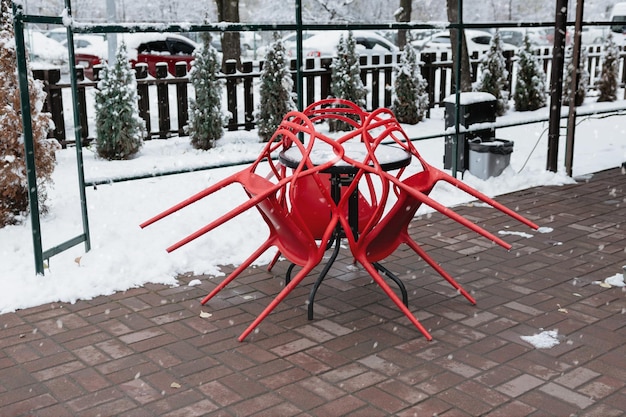 Folded cafe chairs on an outdoor terrace in winter Snowfall on the cafe terrace