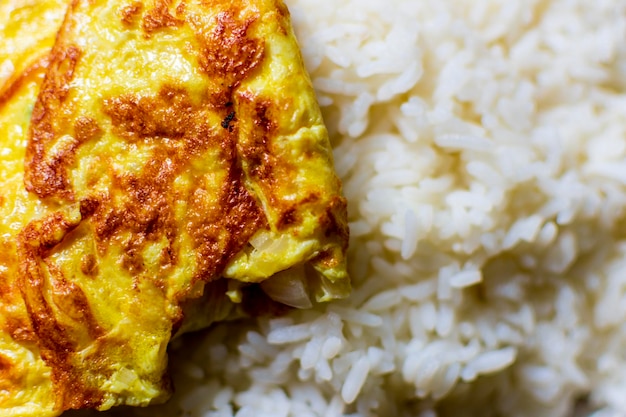 Folded egg omelet kept on the hot rice on a dining plate healthy Indian food habit